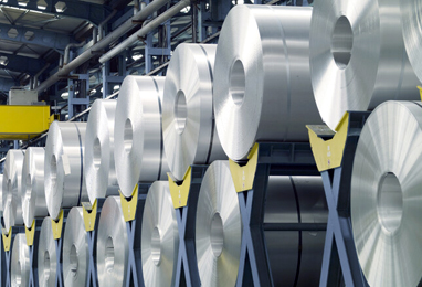 Aluminium coils stacked inside a metal warehouse